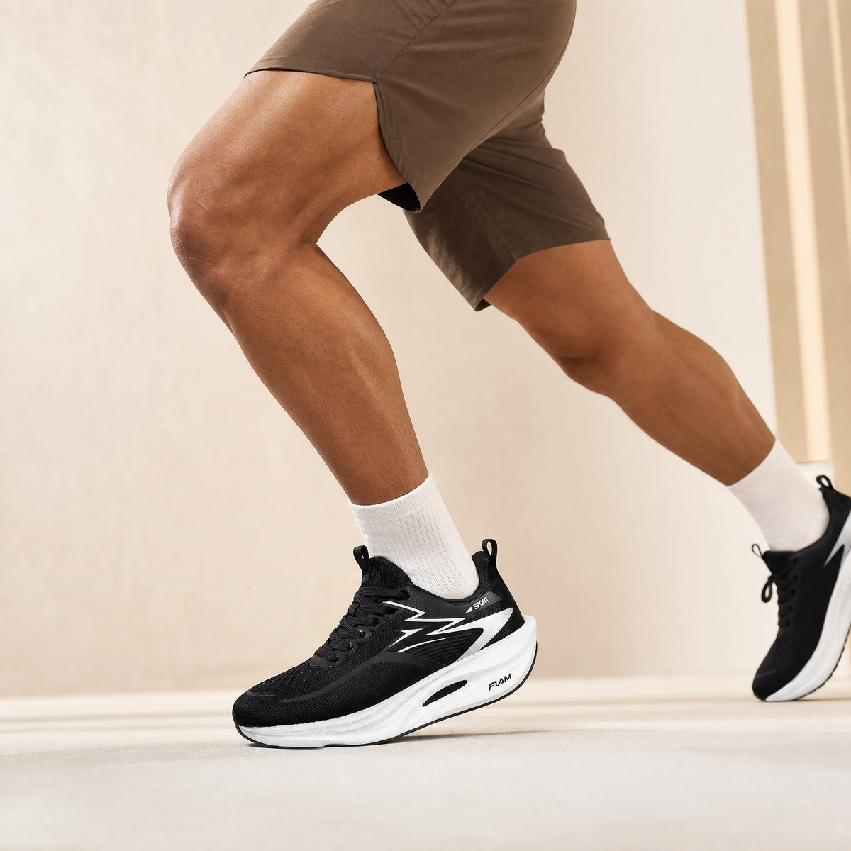 Black air-cushion running shoe worn by a runner, cream studio backdrop