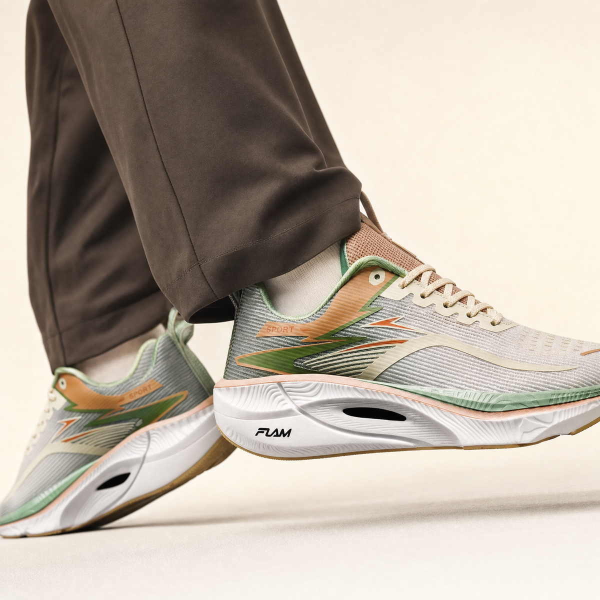 Sand air-cushion running shoe worn by a runner, cream studio backdrop