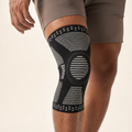 Black compression knee sleeve with silicone patella pad worn by athlete